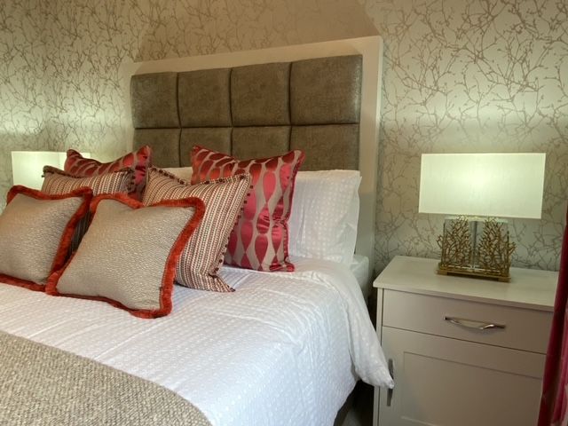 A bedroom with a bed , nightstand and lamps