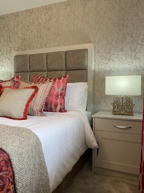 A bedroom with a bed a nightstand and a lamp