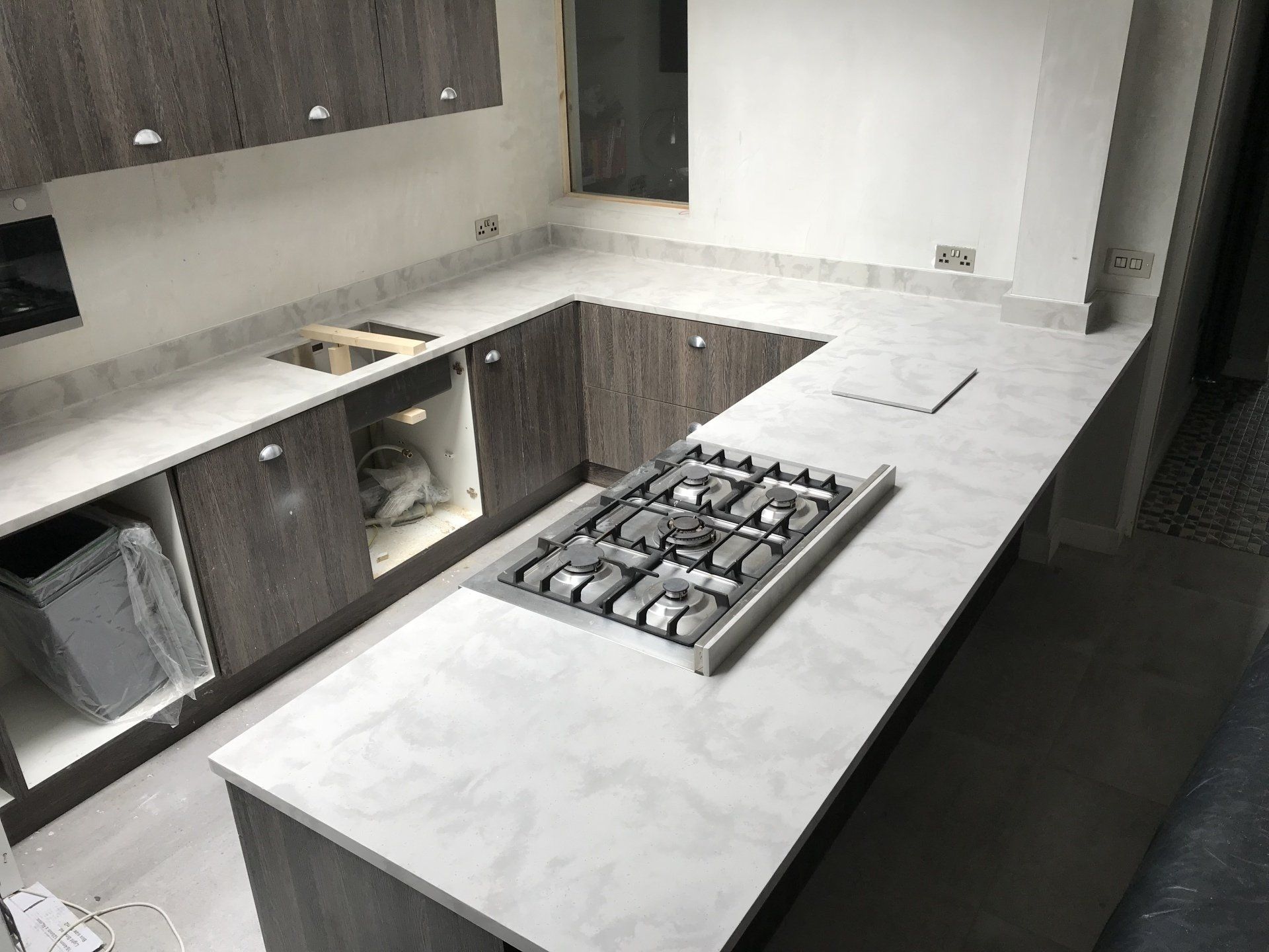 A kitchen with a stove top oven and a sink.