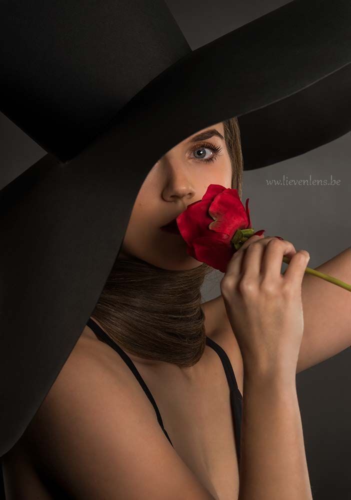 creatief portret in de studio met een hoed en een bloem
