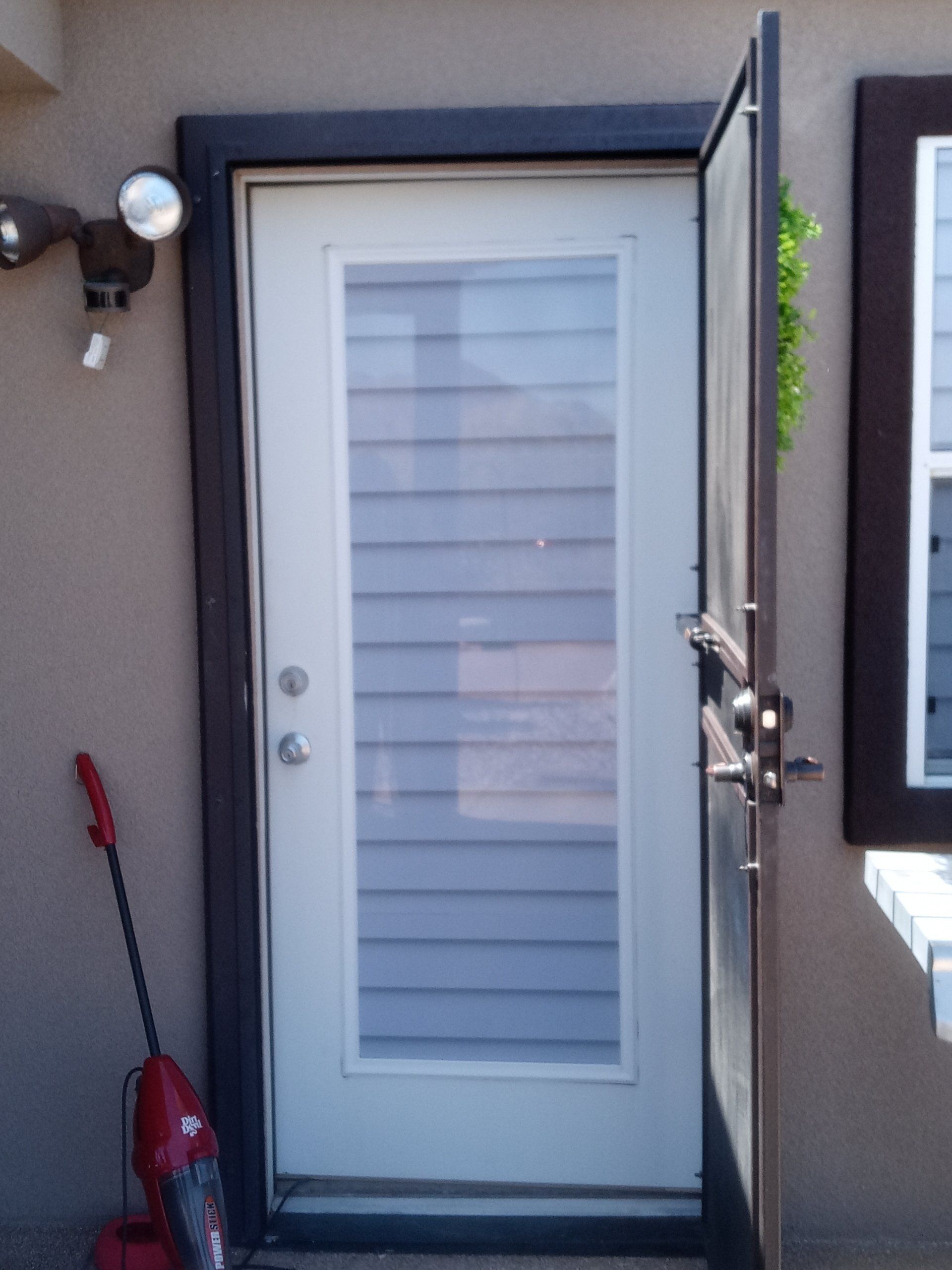 A red vacuum cleaner is next to a white door