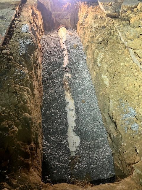 Yellow bulldozer pushing a pile of brown dirt; construction site.