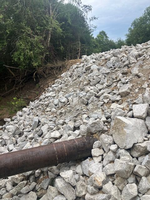 Yellow bulldozer pushing a pile of brown dirt; construction site.