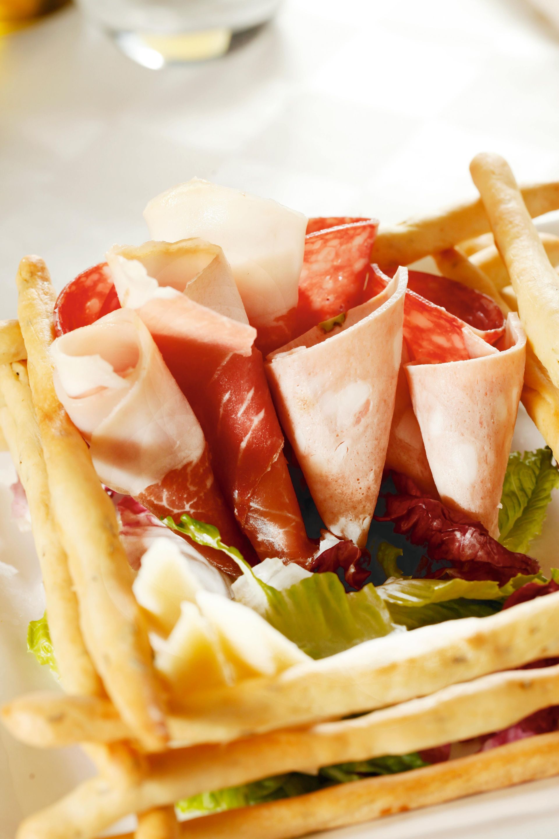 A plate of lettuce-wrapped strawberry slices with breadsticks and a creamy dip