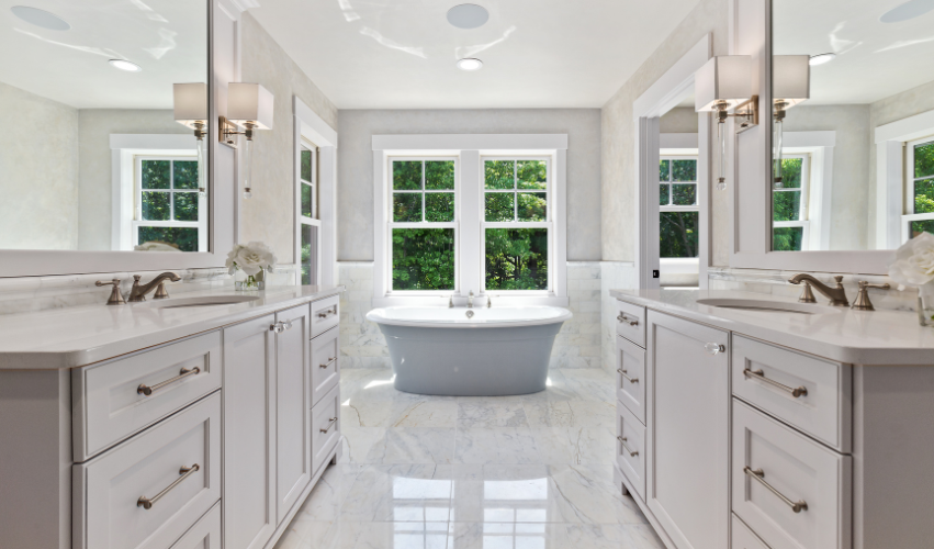 A bathroom with two sinks , a mirror and a walk in shower.