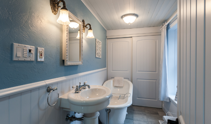 A bathroom with a toilet , sink , shower and mirror.