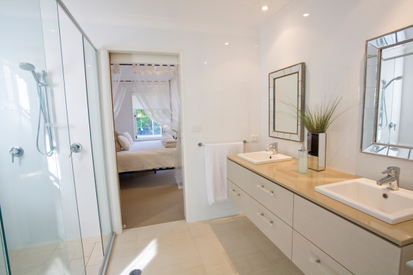 A bathroom with two sinks and a walk in shower