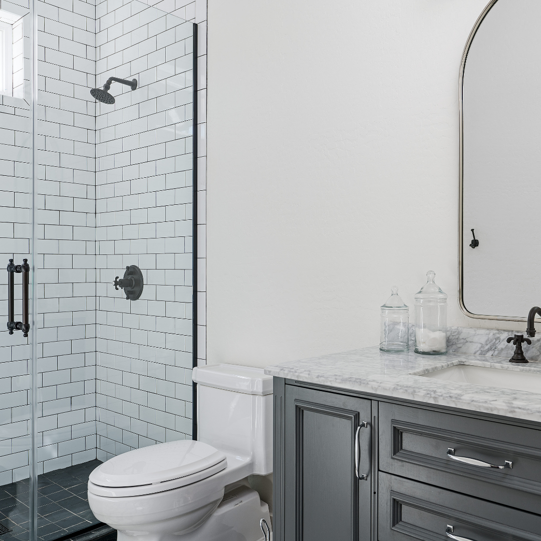A bathroom with a toilet , sink , mirror and shower.