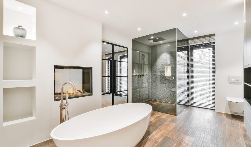 A bathroom with a toilet , sink , mirror and walk in shower.