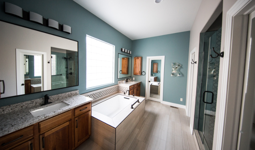 A bathroom with a bathtub , sinks , mirrors and plants.