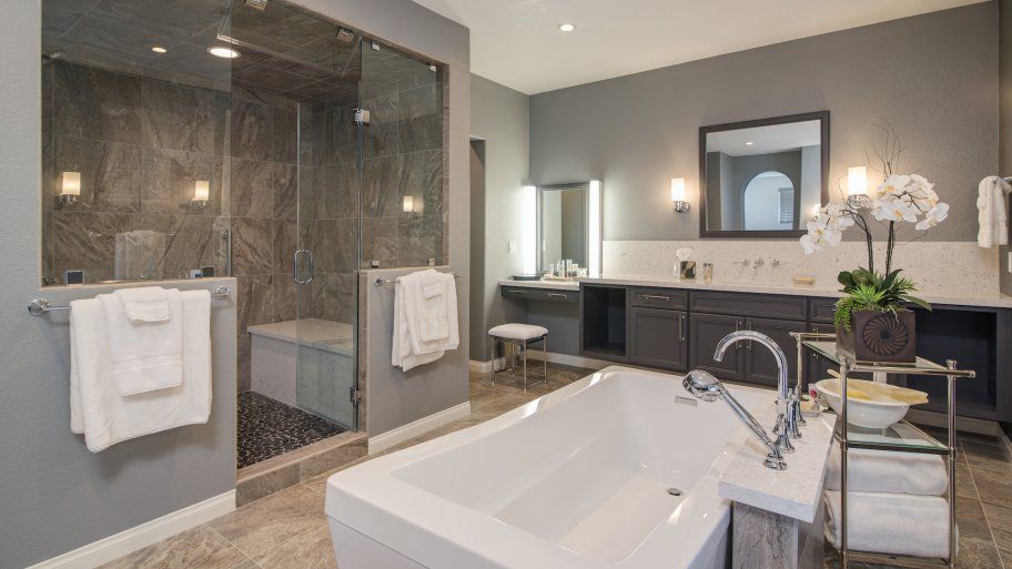 A bathroom with a bathtub , sink , shower and mirror.