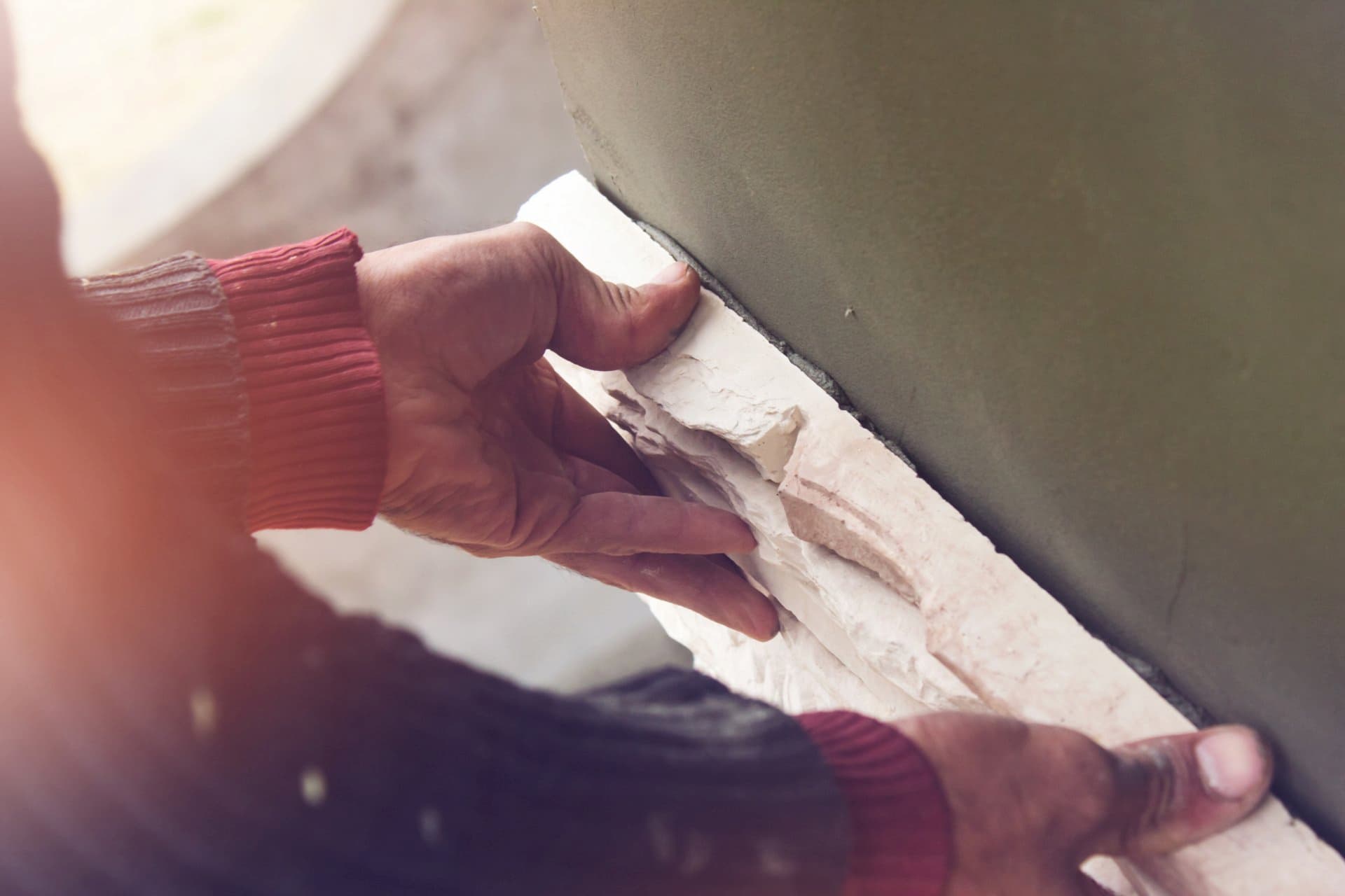 Man Putting Artificial Stone on Wall — Cannonvale Concrete Products in Cannonvale, QLD