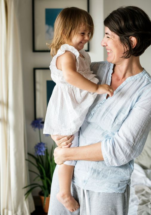 A woman is holding a little girl in her arms.