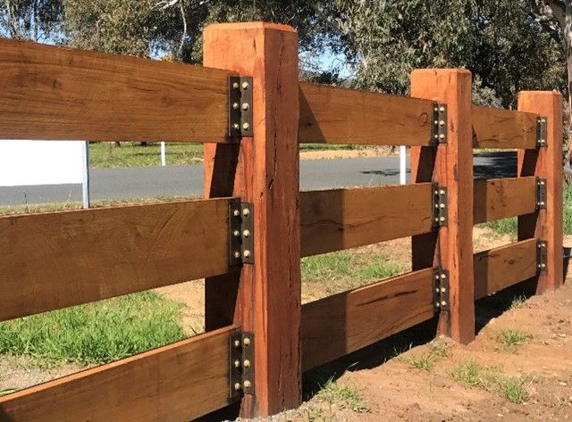 A wooden fence with a white sign in the background