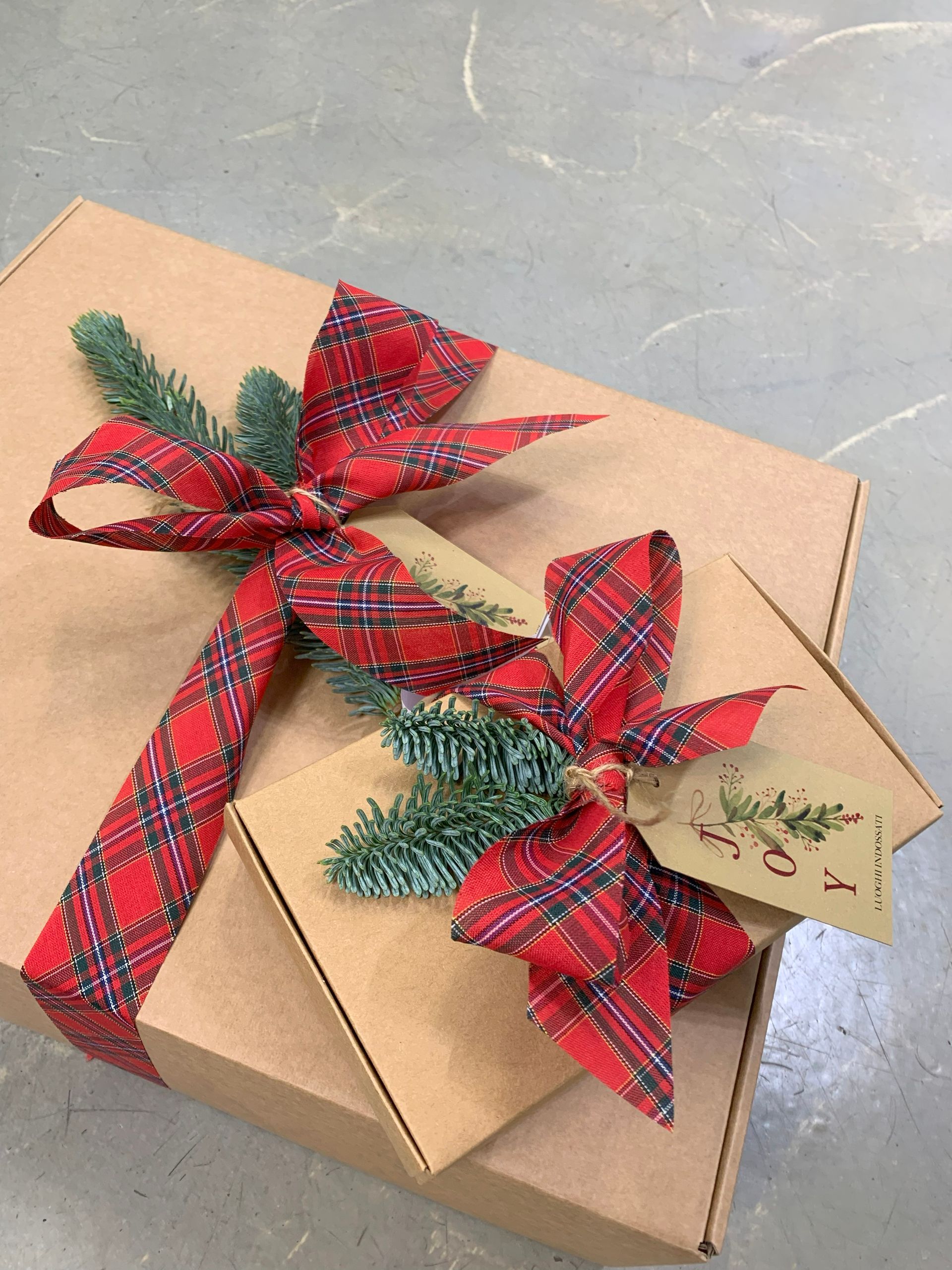 Abito nero su manichino, collana d'argento. Allestimento di un negozio con pareti bianche e sfondo a motivi.