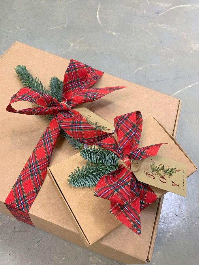 Due borse tote argentate appese a un albero di Natale decorato con ornamenti dorati.