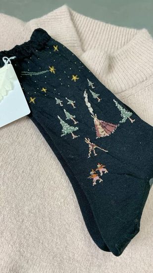 Scatole e decorazioni a forma di stella su una superficie marrone, impreziosita da dettagli dorati e bianchi.