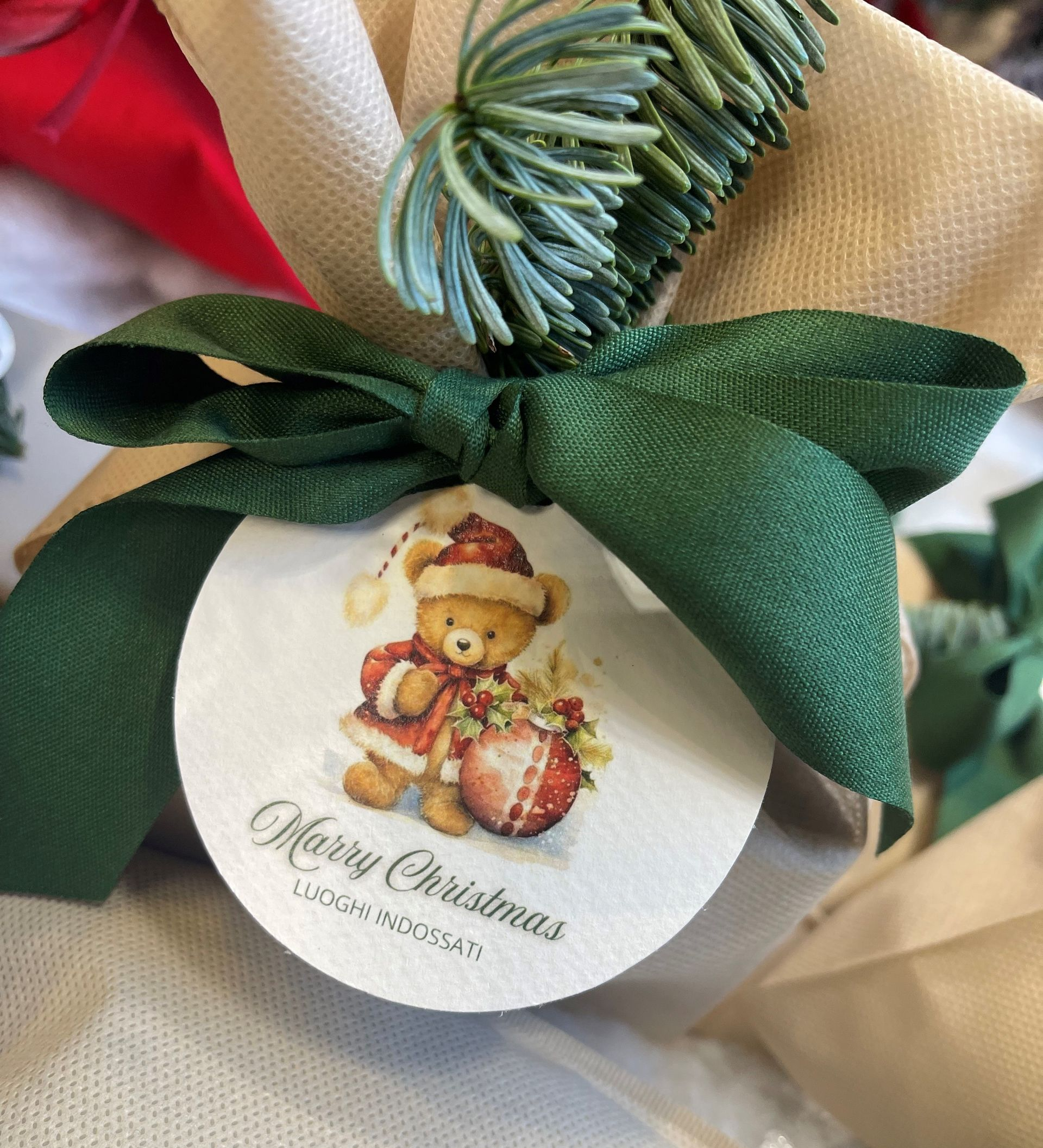 Abito nero su manichino, collana d'argento. Allestimento di un negozio con pareti bianche e sfondo a motivi.