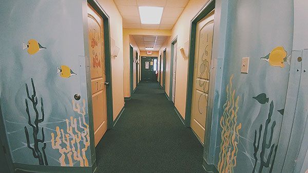 A long hallway with a painting of fish on the doors.