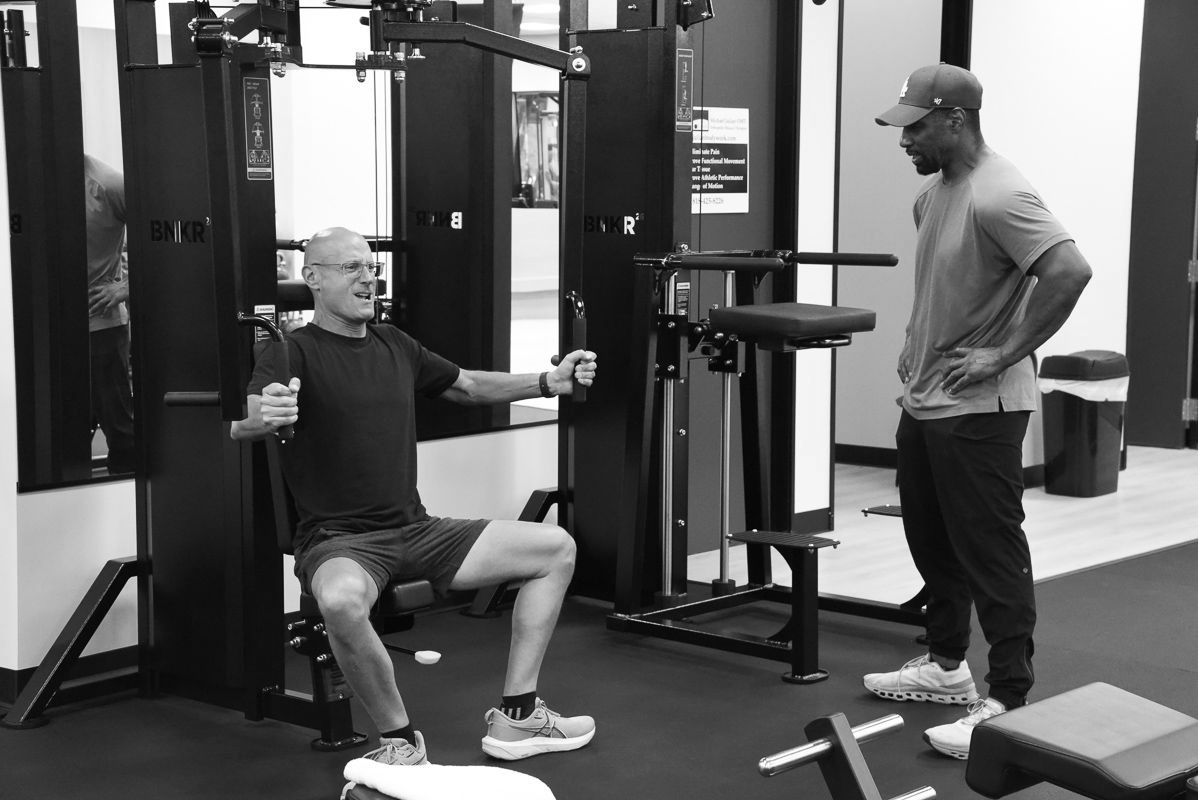 Woman doing a criss-cross crunch exercise on a blue mat, wearing black athletic wear.