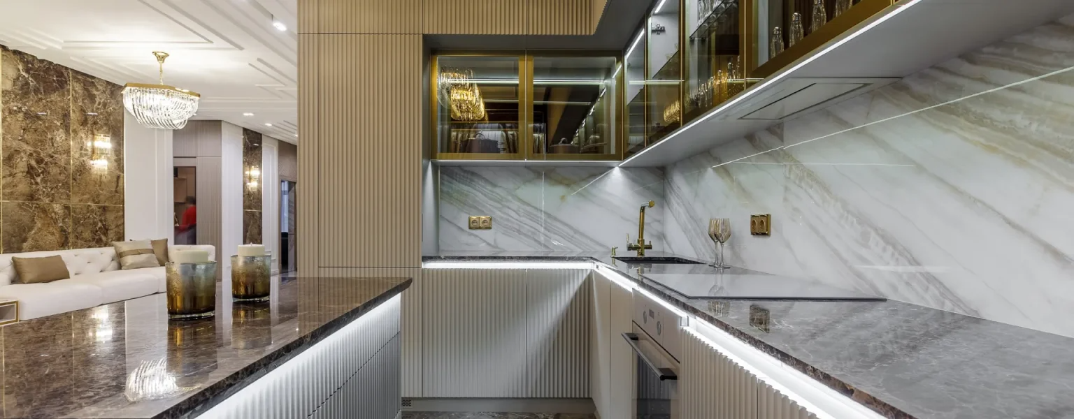 A kitchen with a marble counter top and a stove top oven.