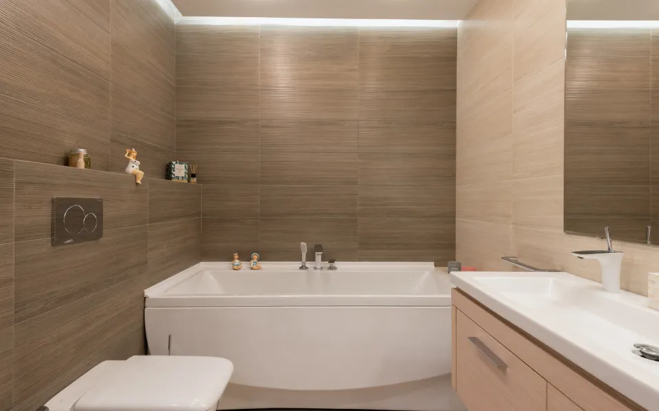 A bathroom with a bathtub , toilet , sink and mirror.