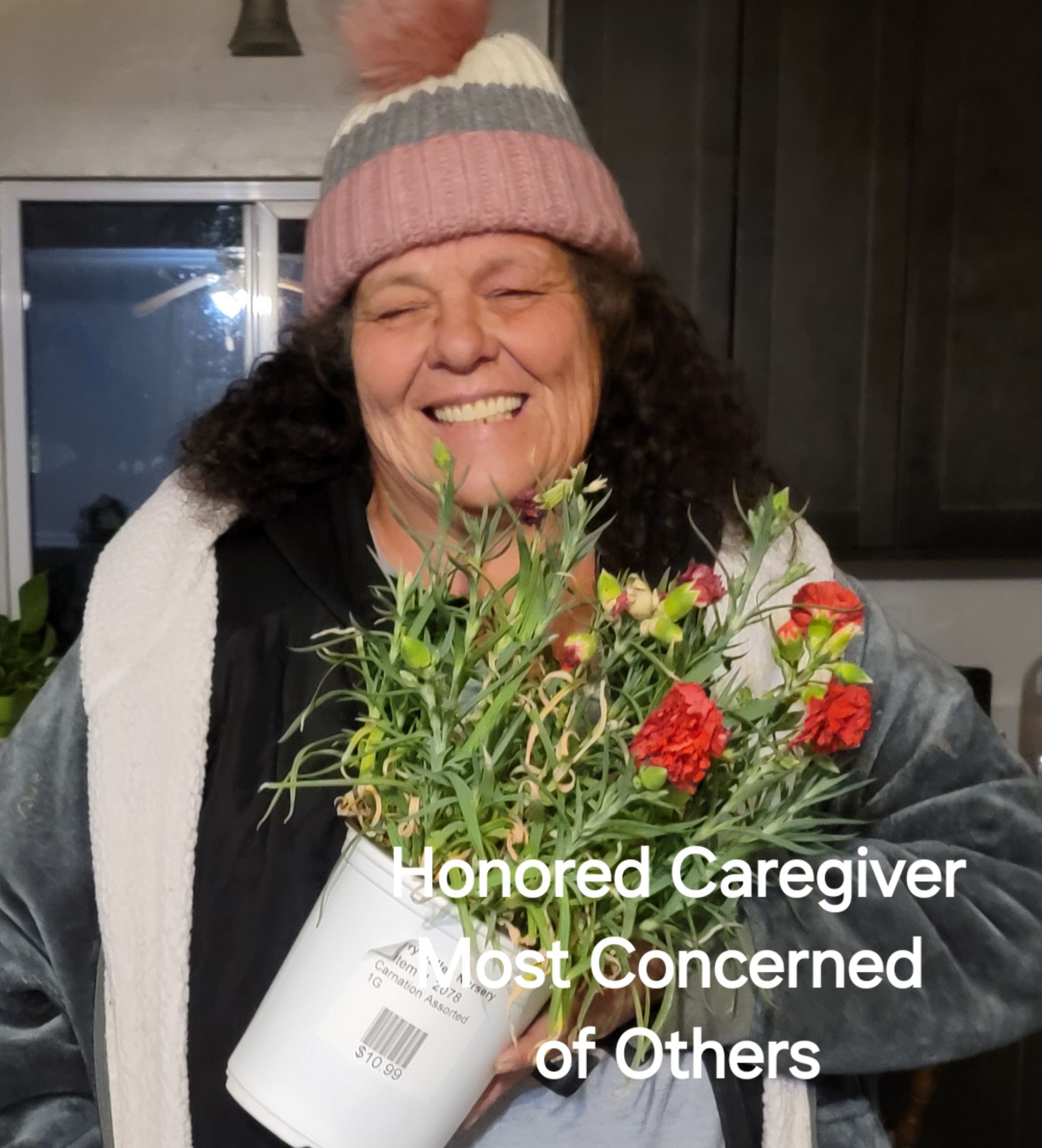 A woman in a pink hat is holding a bouquet of flowers
