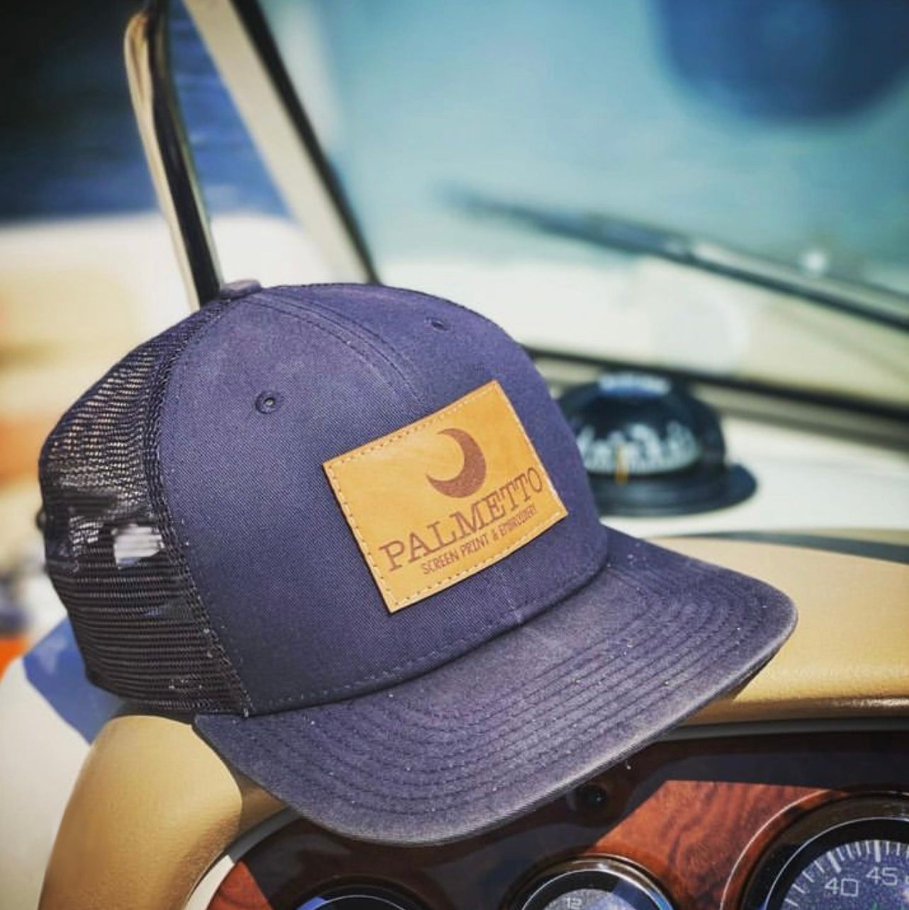 A palmetto hat is sitting on the steering wheel of a boat