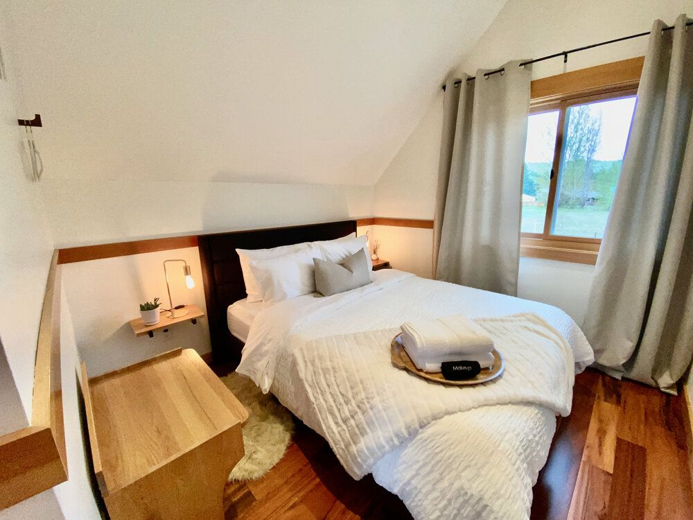 A bedroom with a large bed and a window