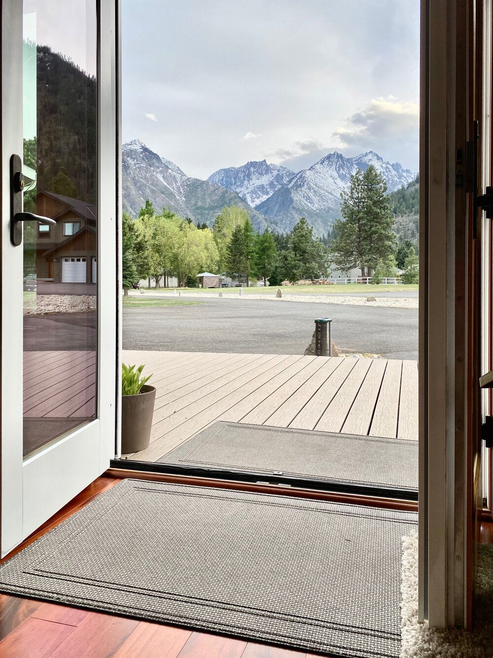 A doorway with a doormat on the floor and mountains in the background