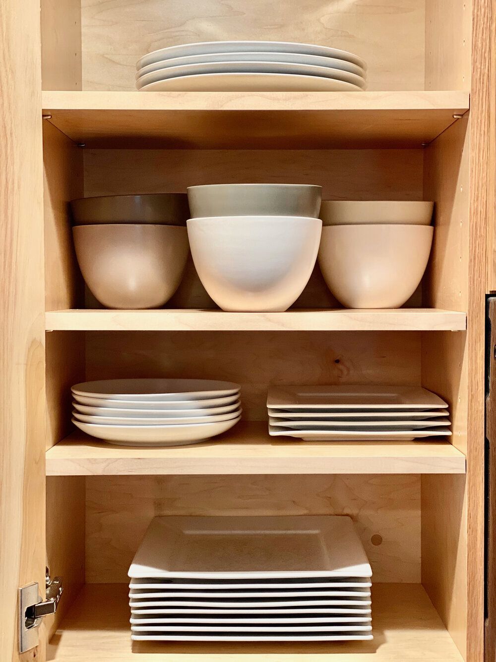 A wooden cabinet filled with bowls and plates.