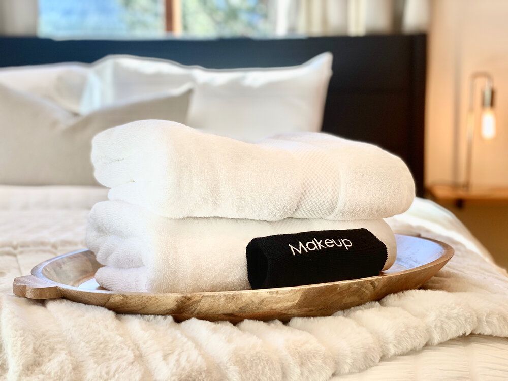 A tray of towels is sitting on top of a bed.