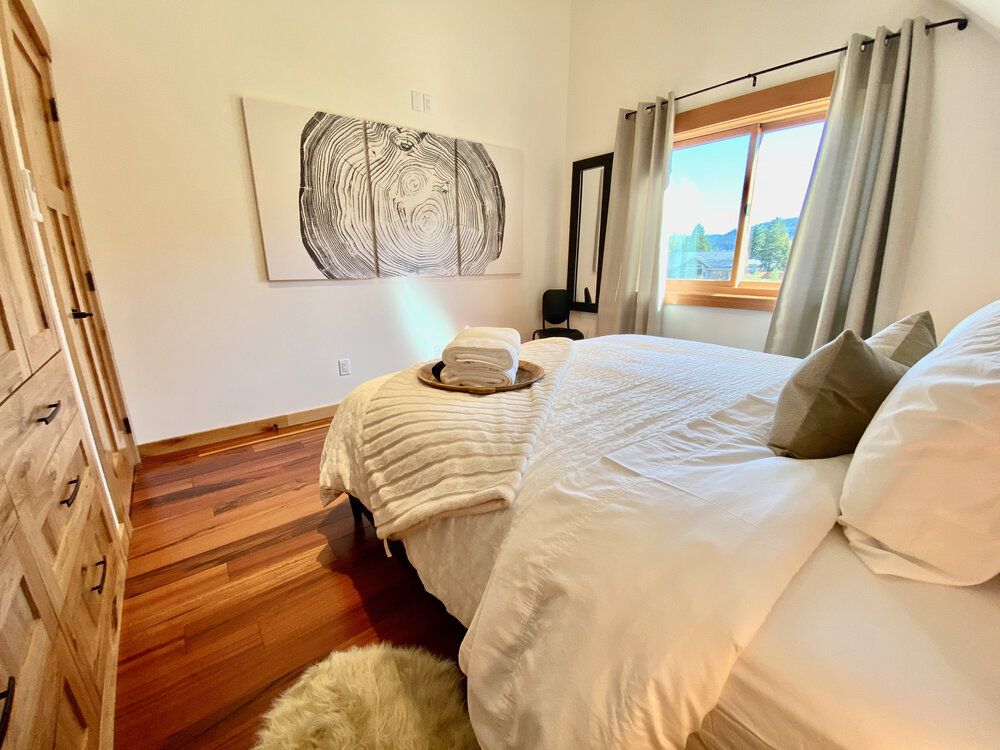 A bedroom with a large bed, dresser, and window.
