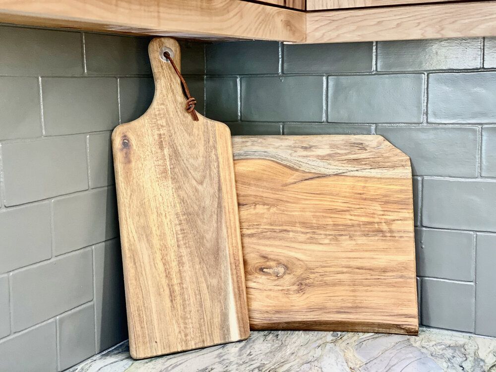 Two wooden cutting boards
sitting on a counter in a kitchen.