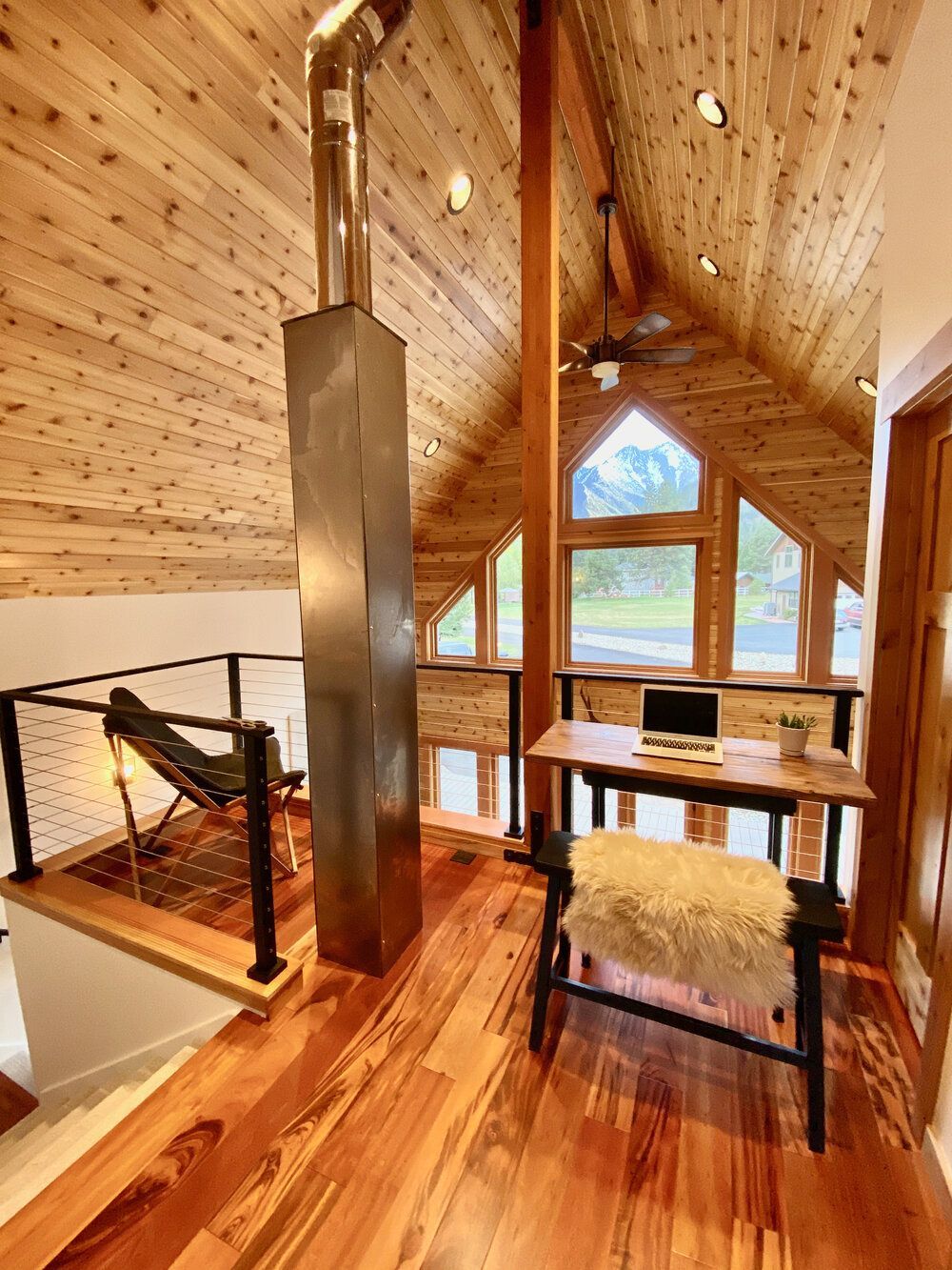 A room with wooden floors and a desk with a laptop on it