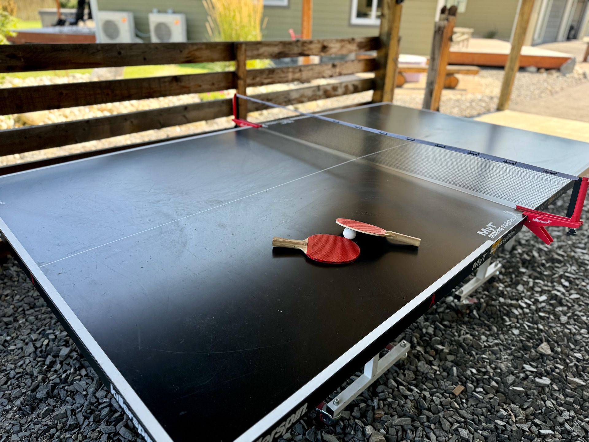 A ping pong table with two ping pong rackets on it.