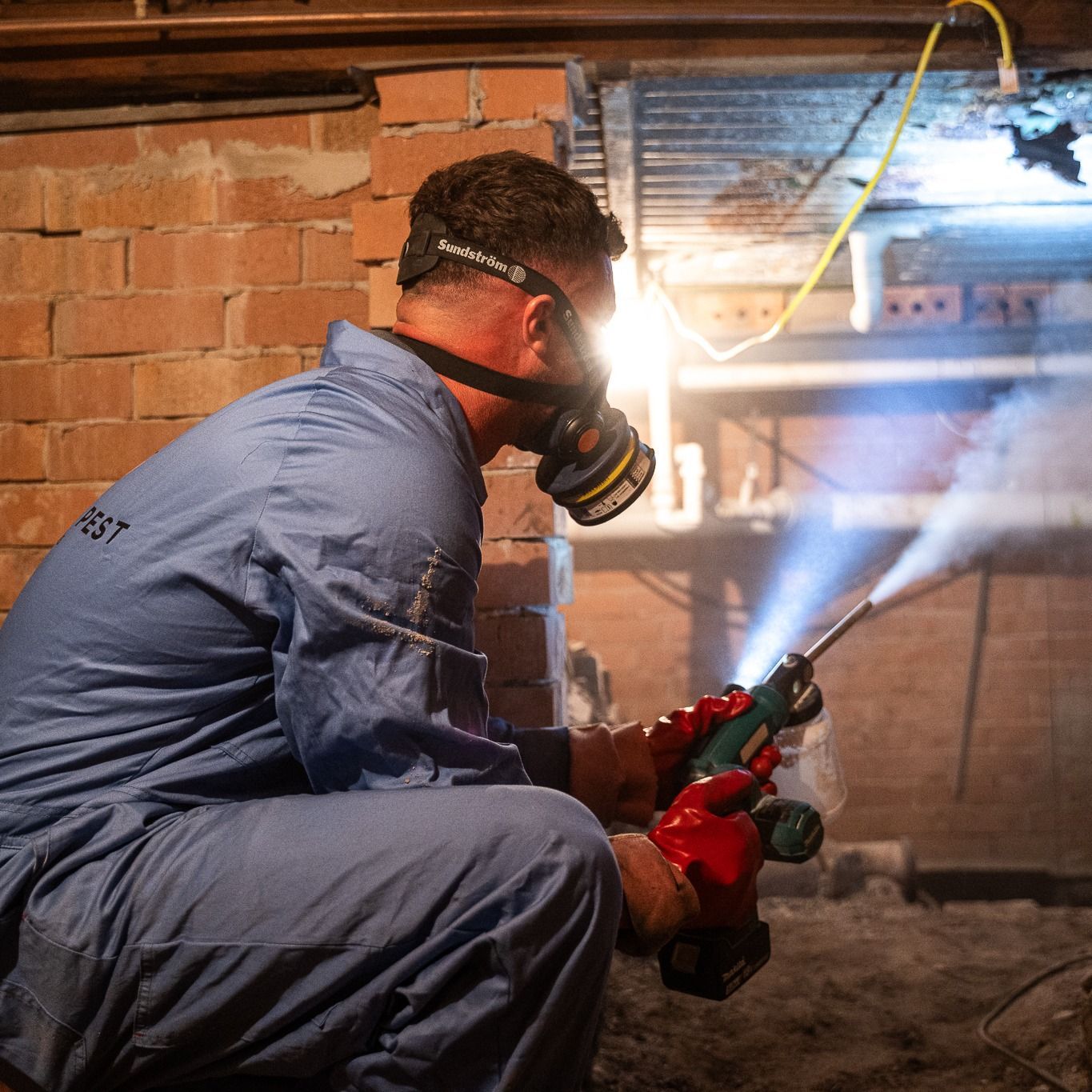 Pest Control Worker Spraying Insecticide in Crawl Space — Premier Pest Control Wollongong In Penrith, NSW