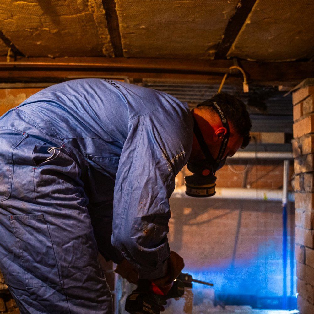 A Man Wearing A Gas Mask Is Working In A Basement — Premier Pest Control Wollongong In Wollongong, NSW