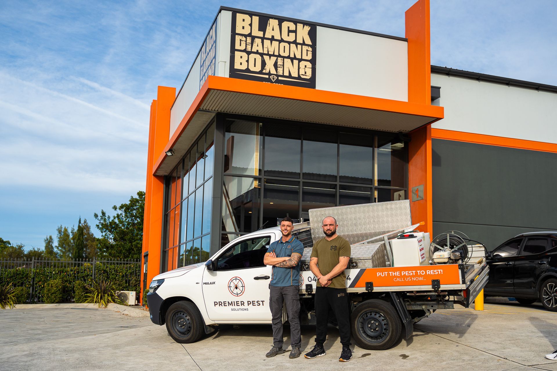 A Man Is Cleaning A Brick Wall With A Hose — Premier Pest Control Wollongong In Corrimal, NSW