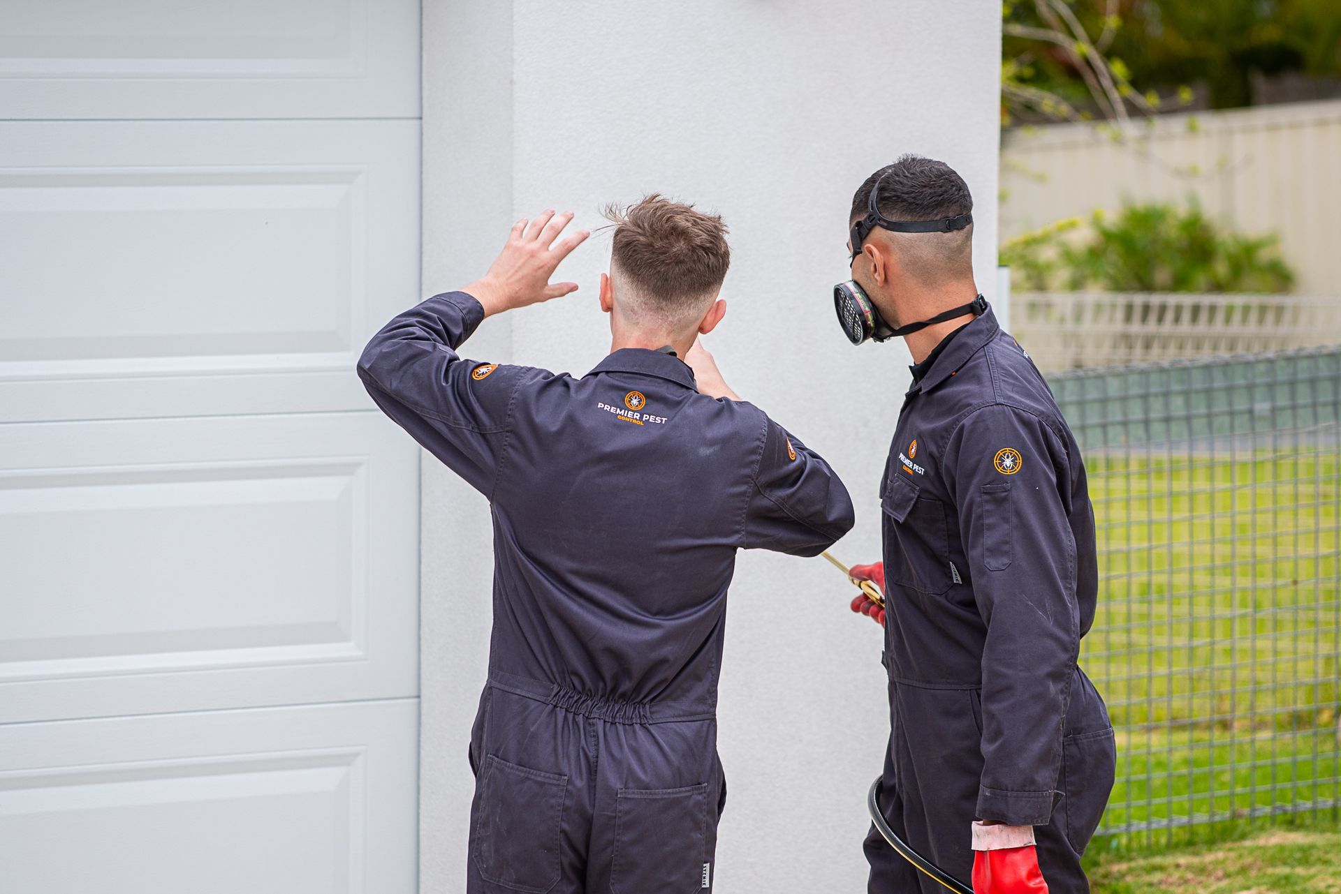 A Person In A Yellow Suit Is Spraying A Carpet With A Sprayer — Premier Pest Control Wollongong In Corrimal, NSW