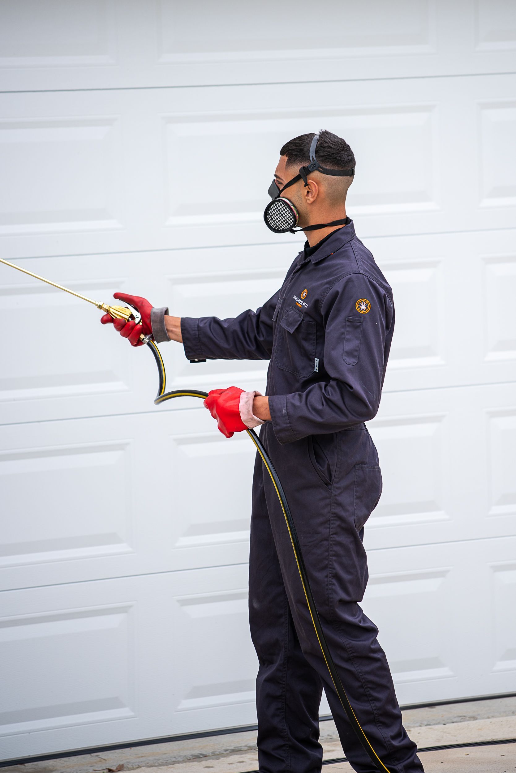 A Man Wearing A Mask Is Working On A AEG Tool Bag — Premier Pest Control Wollongong In Wollongong, NSW