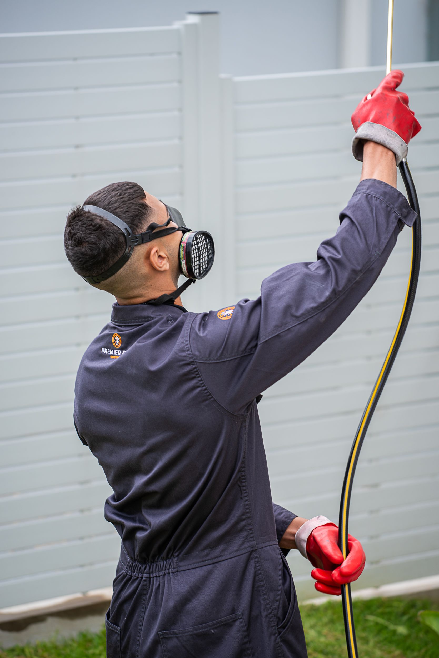 A Man Is Spraying A Hose On A Wooden Floor — Premier Pest Control Wollongong In Wollongong, NSW