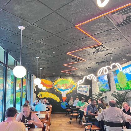 A group of people are sitting at tables in a restaurant.