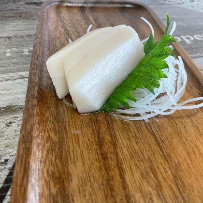 A wooden tray with a piece of food on it.