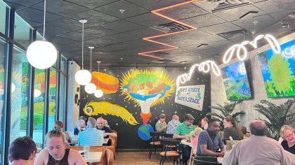 A group of people are sitting at tables in a restaurant.