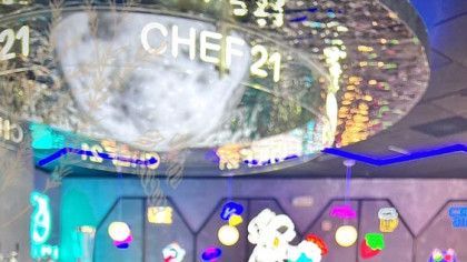 A chef 21 sign is hanging from the ceiling of a restaurant.