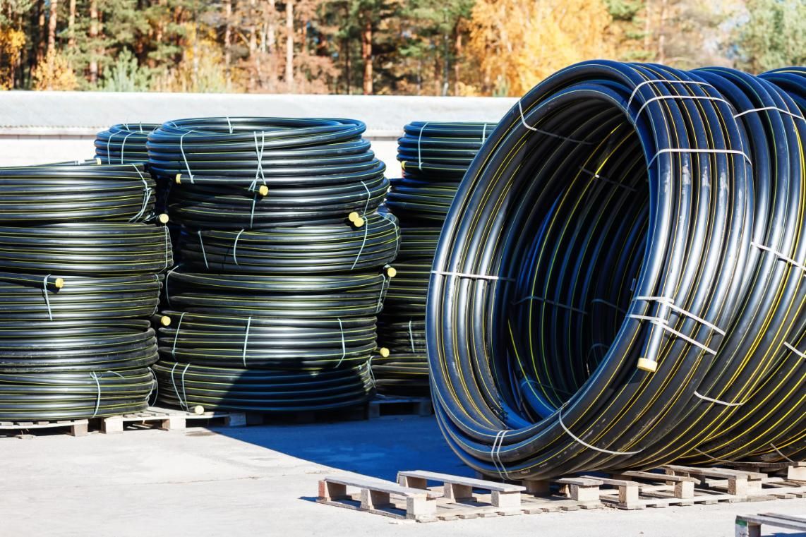 A Bunch Of Plastic Pipes Are Stacked On Top Of Each Other On Pallets — NQPT In Garbutt, QLD