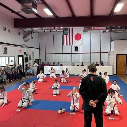 A group of people are practicing martial arts in a gym