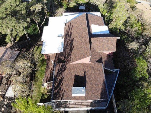 An aerial view of a house with a brown roof