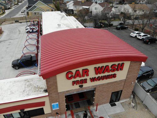 An aerial view of a car wash with cars parked in front of it